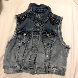 Denim button up vest with cute purple ruffles on the shoulders.